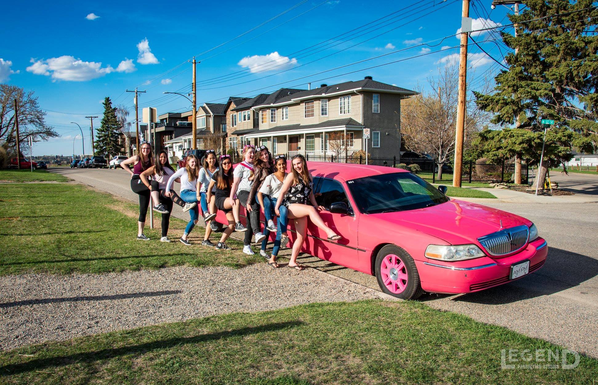 9 ladies standing along side the Pink Stretch Limousine for a Bachelorette