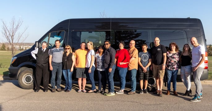 Group photo in front of a black Mercedes Mini Party Bus