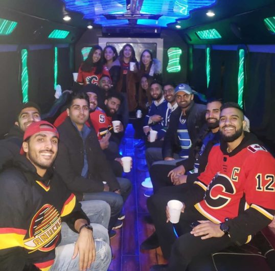 Group inside of party buses, all wearing hockey jerseys